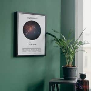 Een ingelijste geboorteposter met het sterrenbeeld Waterman hangt aan een groene muur. De poster is gepersonaliseerd met de naam Tamara, geboortedatum, geboorteplaats, en tijdstip van geboorte. Op de achtergrond staat een groene kamerplant op een bijzettafeltje, wat zorgt voor een serene en stijlvolle sfeer.